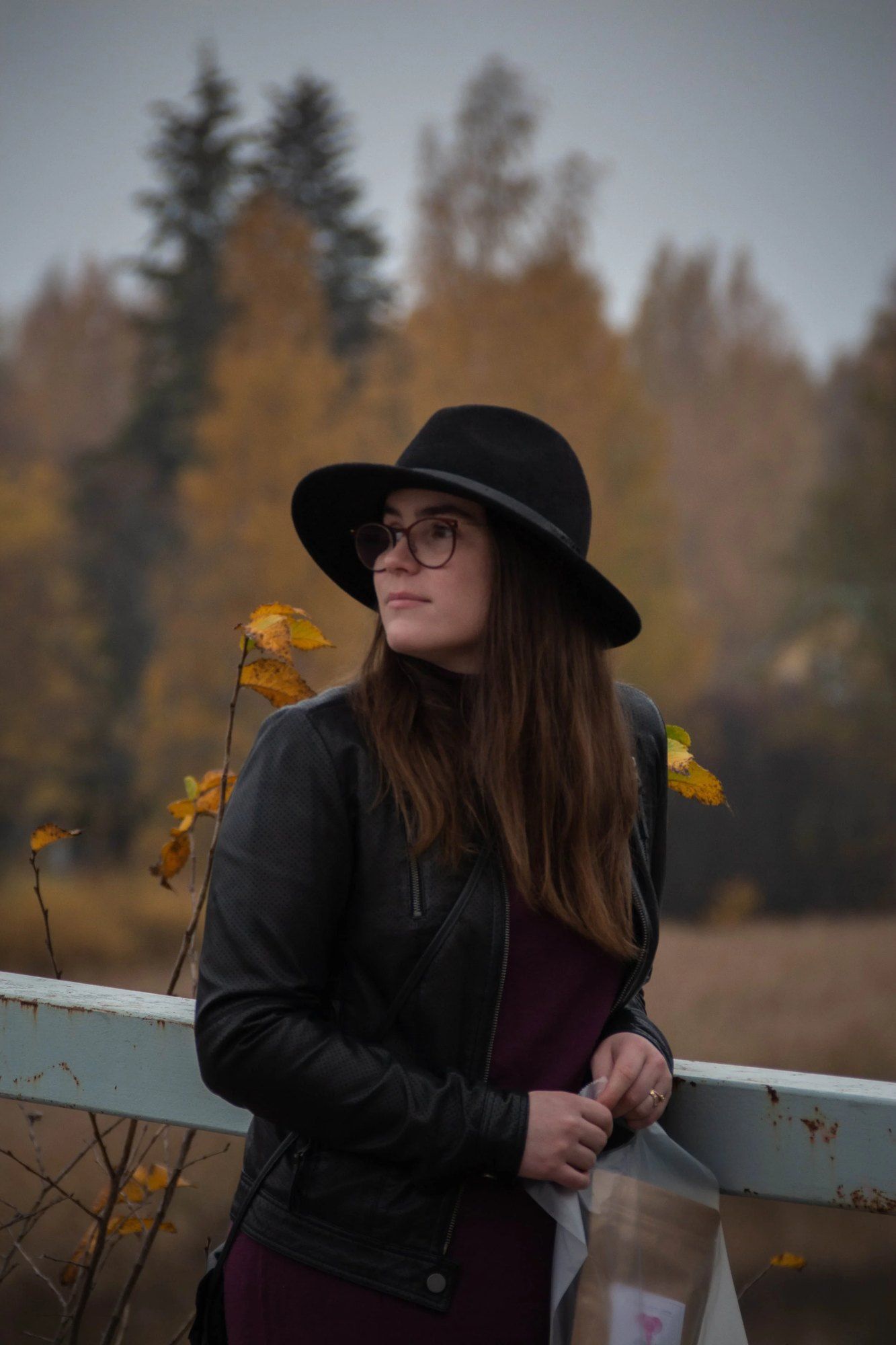 Hattupäinen nainen syksyisessä maisemassa